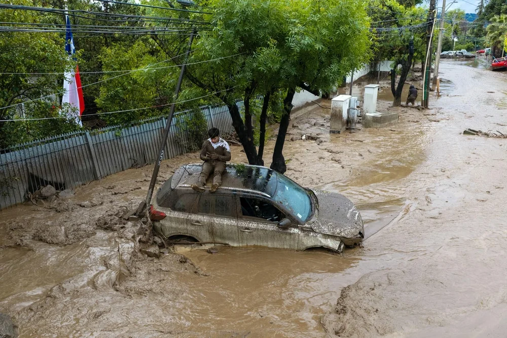 una-persona-se-resguarda-un-vehiculo-afectado-un-aluvion-este-jueves-la-comuna-las-condes-santiago-c (1)